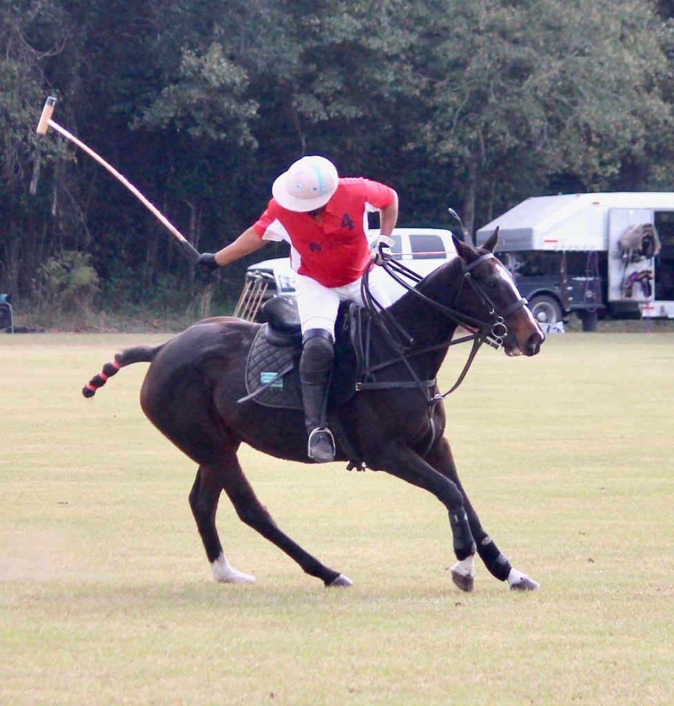 Polo rider swinging mallet.